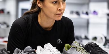 Sportadviseur Maroussia Jen die sportschoenen naast elkaar vergelijkt